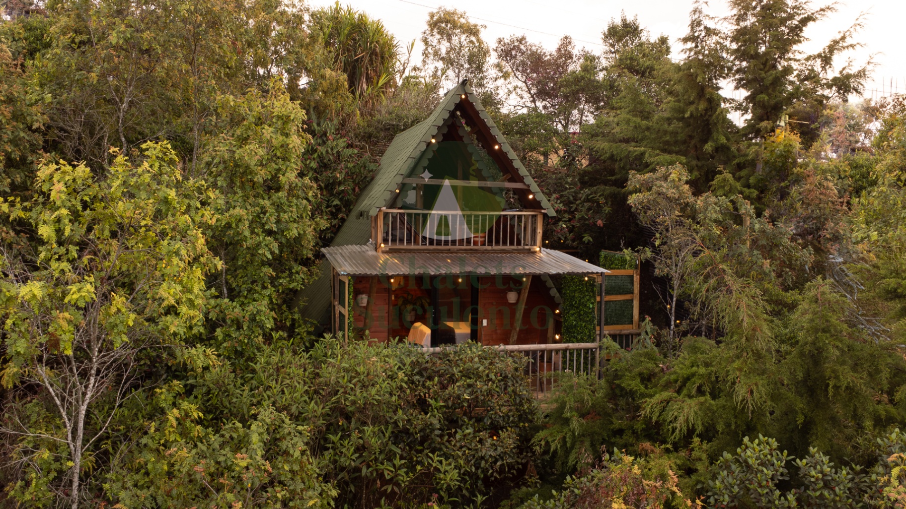 Chalet con techo verde rodeado de árboles en Santa Elena