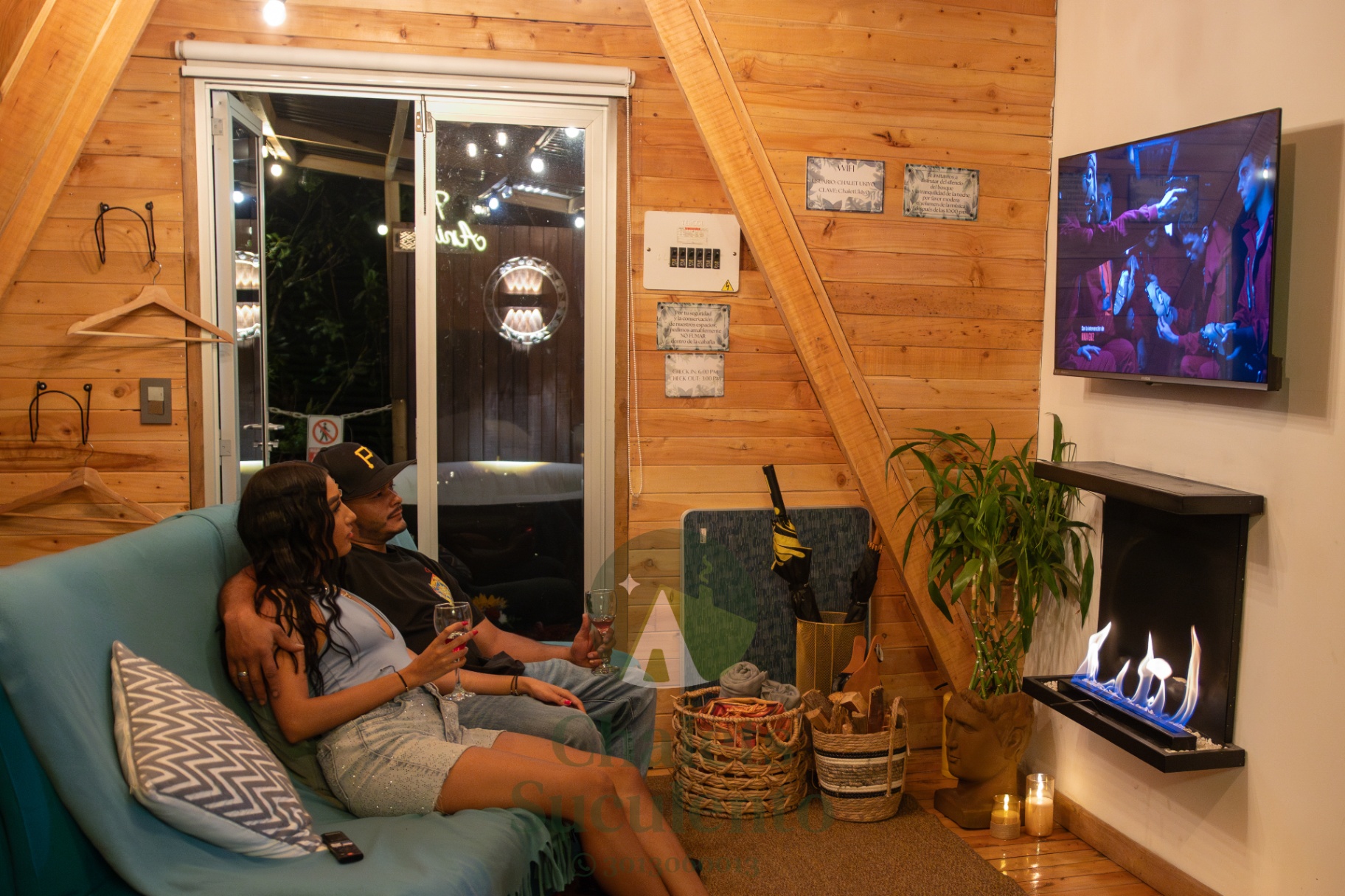 Pareja en el sofá disfrutando de la chimenea y TV